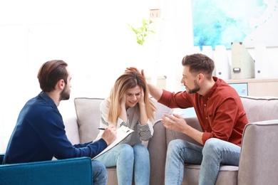 Photo of Family psychologist working with young couple in office
