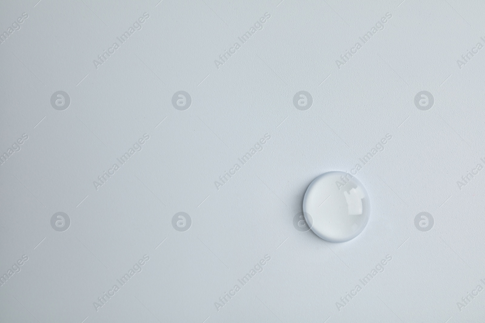 Photo of Water drop on light background, top view