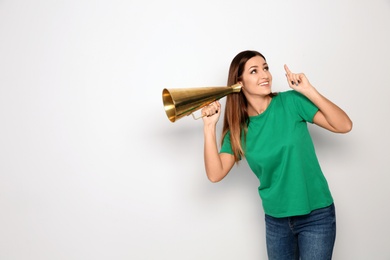 Photo of Young woman with megaphone on white background. Space for text