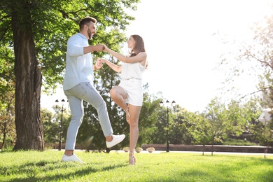 Photo of Lovely young couple dancing together in park on sunny day