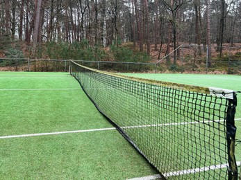 Tennis court with artificial grass and net outdoors