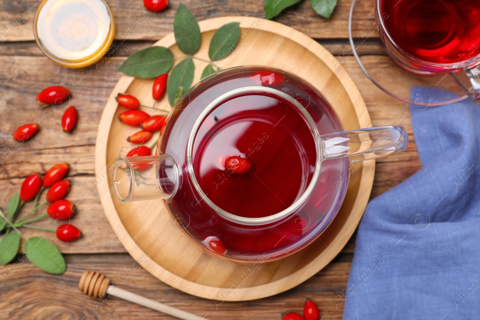 Photo of Flat lay composition with aromatic rose hip tea on wooden table