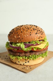 Photo of Burger with delicious patty on light table