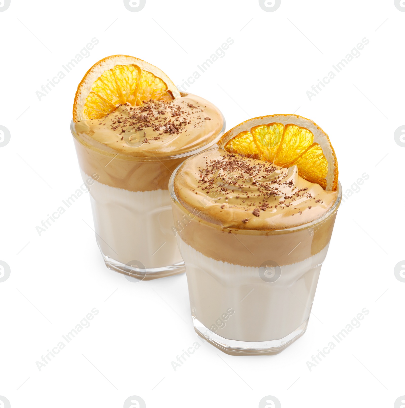 Photo of Glasses of delicious dalgona coffee with dry orange and chocolate isolated on white