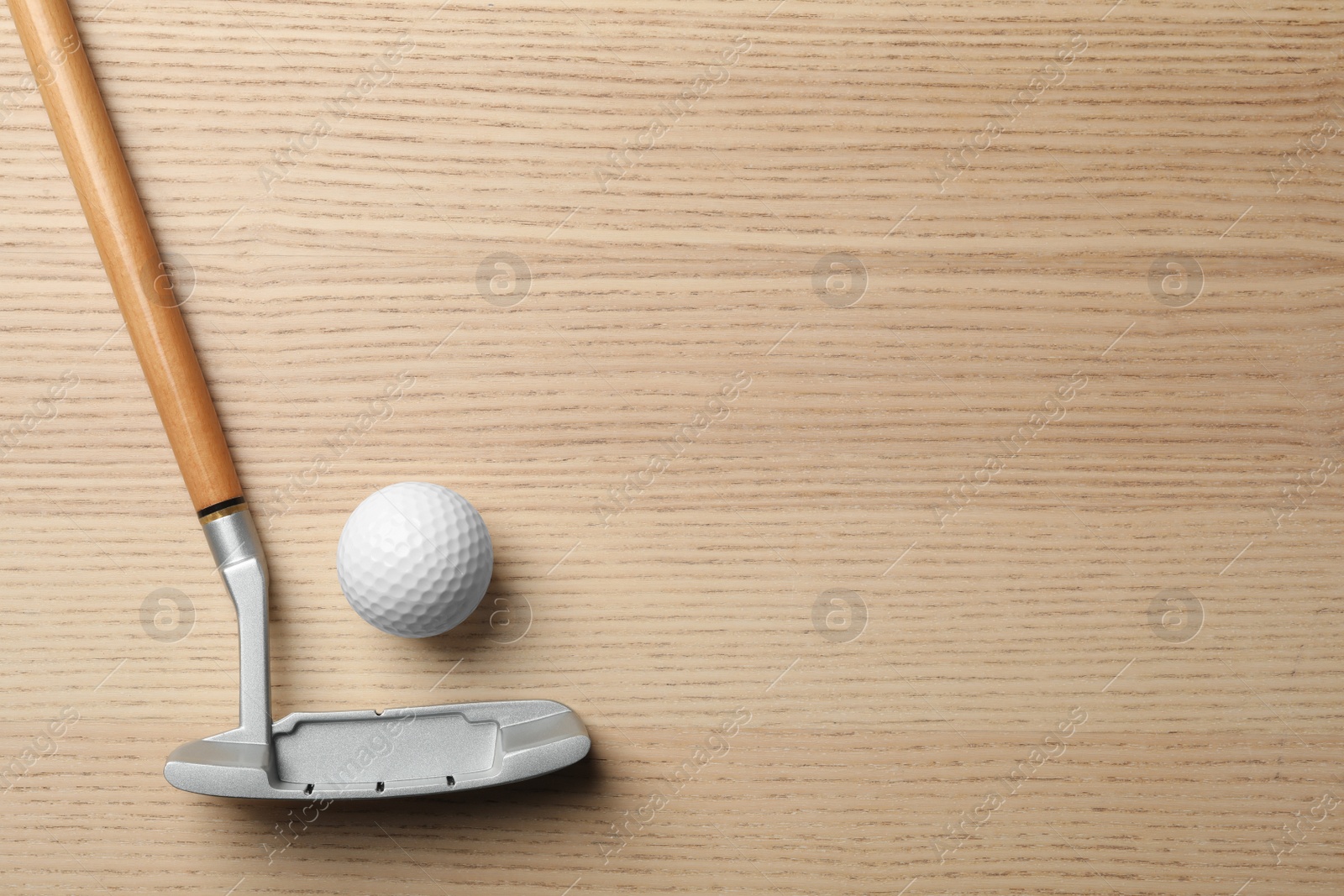 Photo of Golf club and ball on wooden background, flat lay with space for text