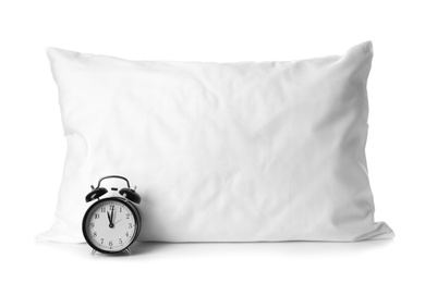 Blank soft pillow and alarm clock on white background