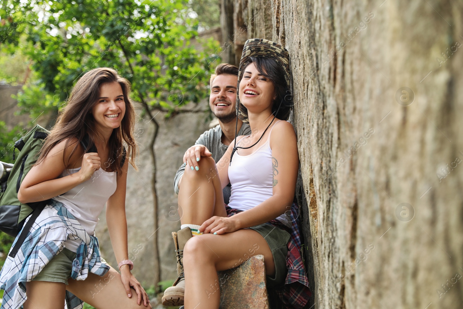 Photo of Young friends near steep cliff on summer day. Camping season