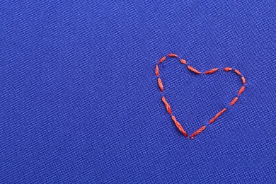 Embroidered heart on blue cloth, top view