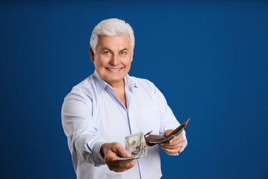 Photo of Happy senior man with cash money and wallet on blue background