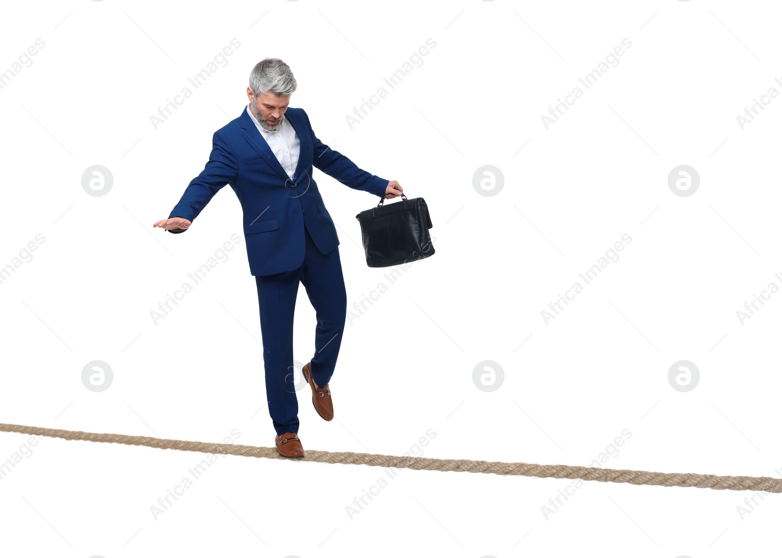 Image of Risks and challenges of owning business. Man with briefcase balancing on rope against white background
