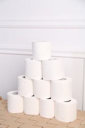 Photo of Pyramid of toilet paper rolls on wicker table