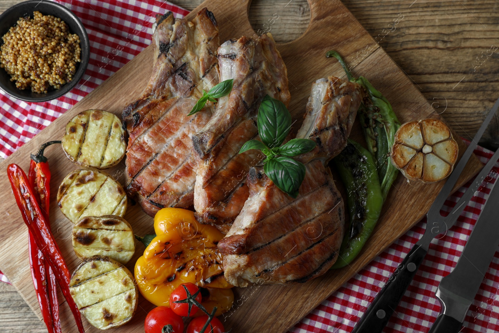 Photo of Delicious grilled meat and vegetables served on wooden table, flat lay