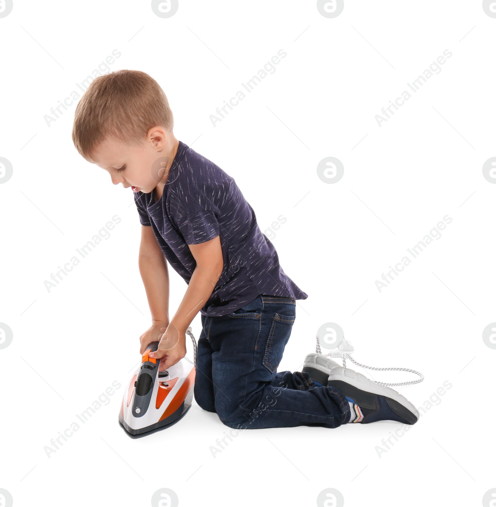 Photo of Little boy playing with iron on white background. Danger at home