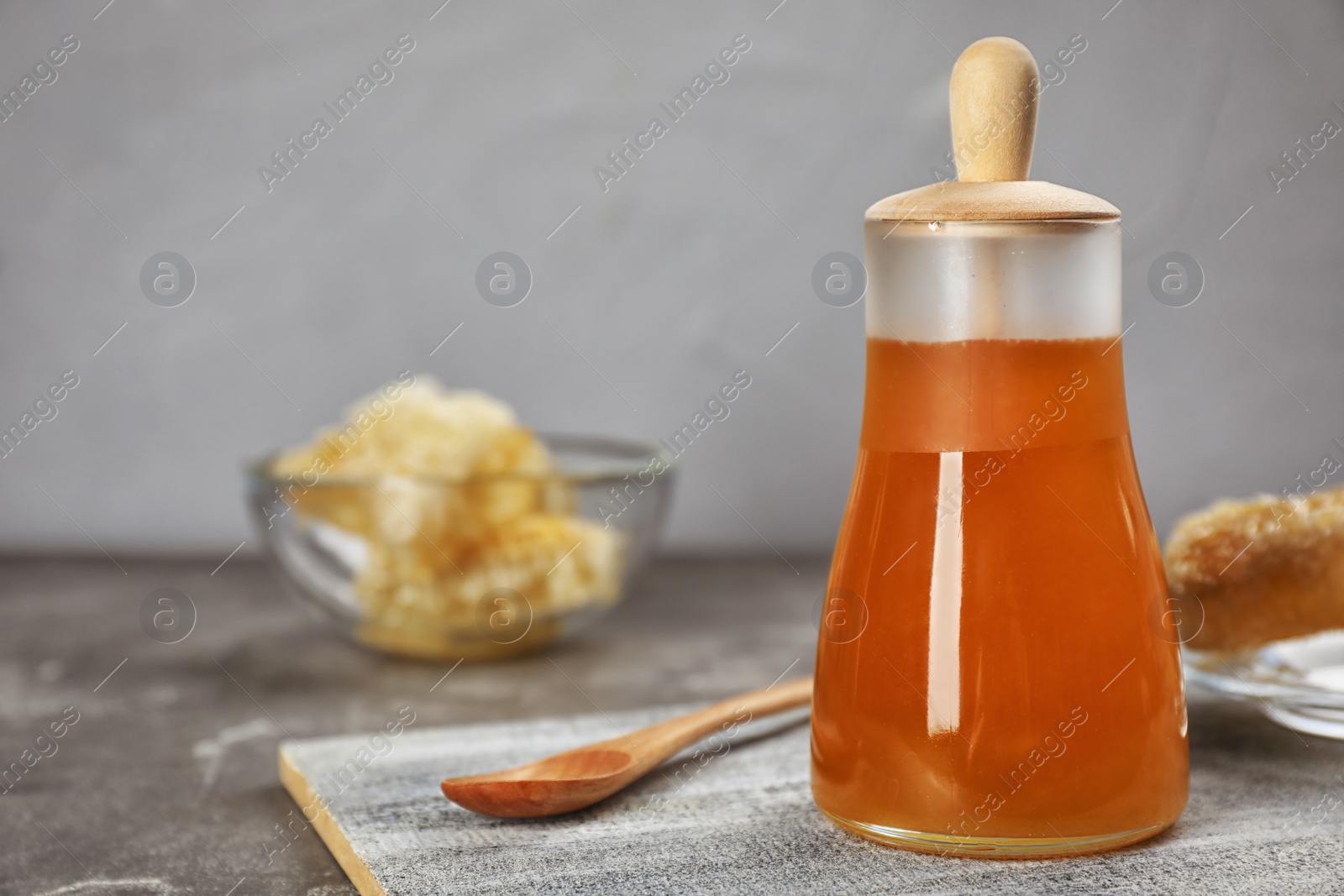 Photo of Jar of honey and spoon on table