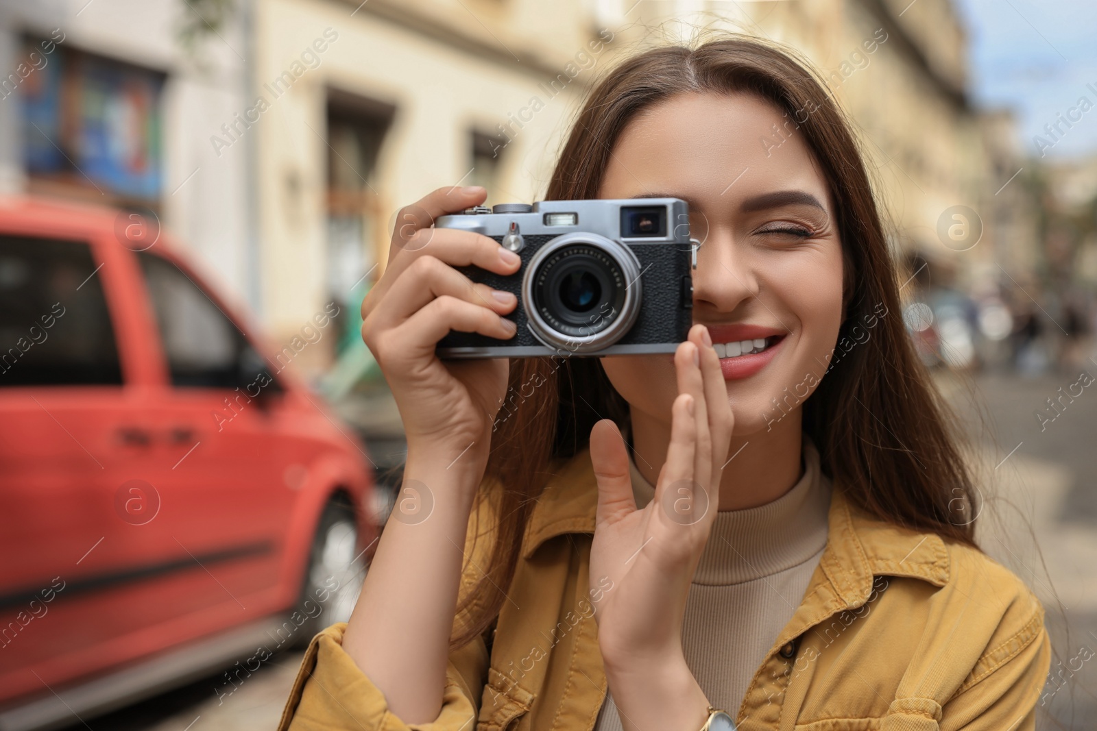 Photo of Young woman with camera taking photo on city street, space for text. Interesting hobby