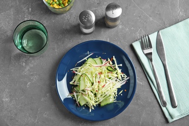 Photo of Flat lay composition with healthy cabbage salad on dark table