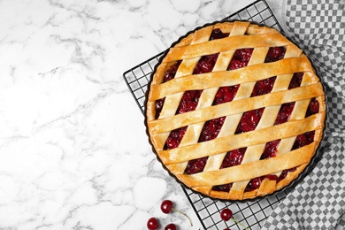 Photo of Flat lay composition with delicious fresh cherry pie on white marble table. Space for text