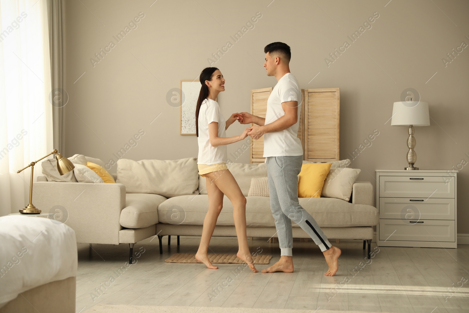 Photo of Happy couple in pyjamas dancing at home