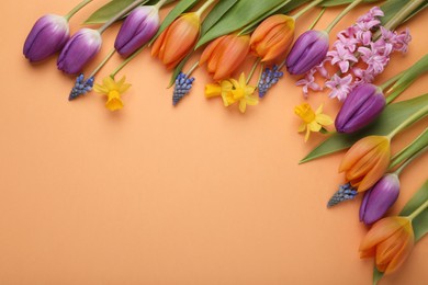 Beautiful different flowers on orange background, flat lay. Space for text