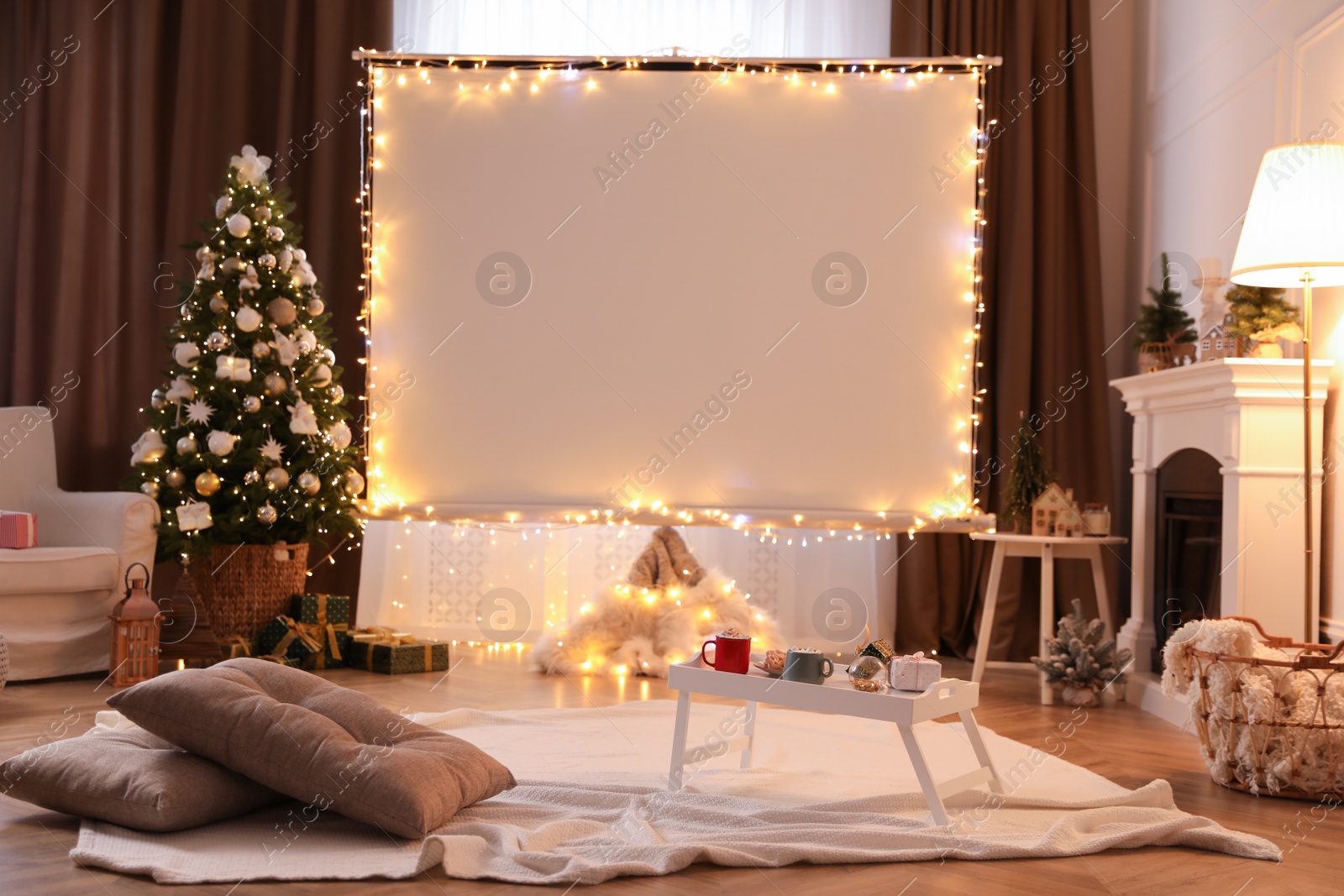 Photo of Blank video projector screen in room decorated for Christmas. Cozy atmosphere