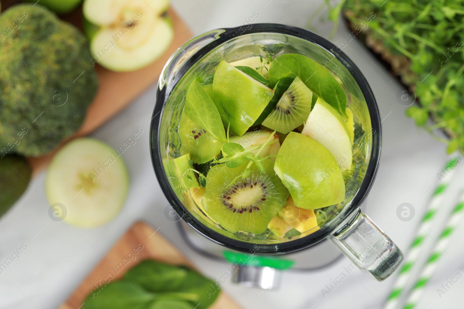 Photo of Blender with ingredients for smoothie on white table, flat lay