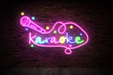 Image of Glowing neon sign with word Karaoke and microphone on brick wall
