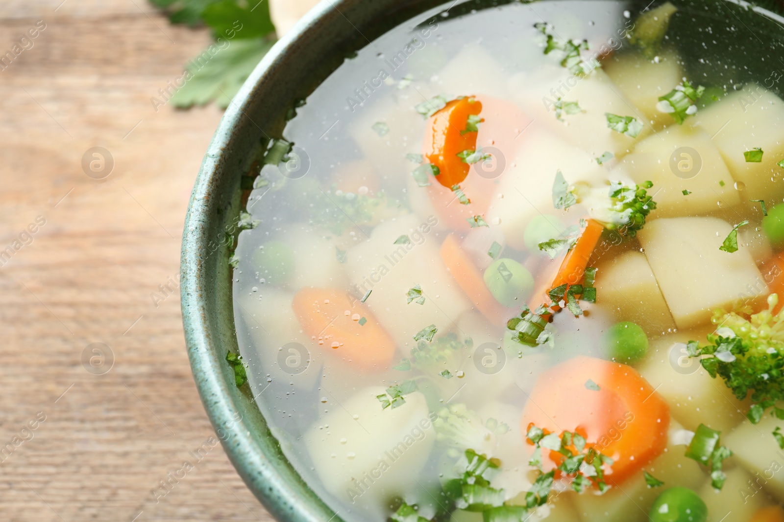 Photo of Bowl of fresh homemade vegetable soup on table, closeup