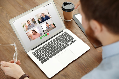 Man having online meeting with his team via laptop, closeup