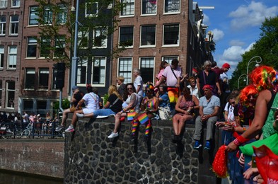 Photo of AMSTERDAM, NETHERLANDS - AUGUST 06, 2022: Many people at LGBT pride parade on bridge of river