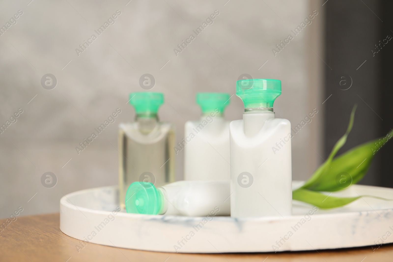 Photo of Mini bottles of cosmetic products on table, closeup. Space for text