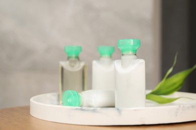 Photo of Mini bottles of cosmetic products on table, closeup. Space for text