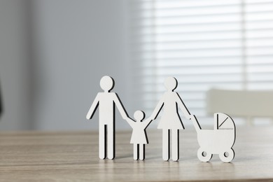 Photo of Family law. Figure of parents with children on light wooden table