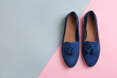 Pair of female shoes on color background, top view