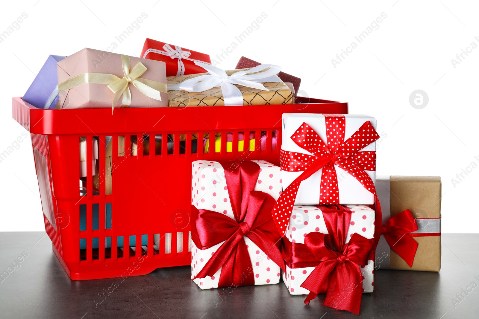 Photo of Shopping basket with different gift boxes on grey table against white background