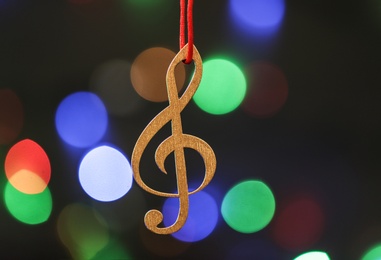 Photo of Wooden treble clef against blurred lights. Christmas music