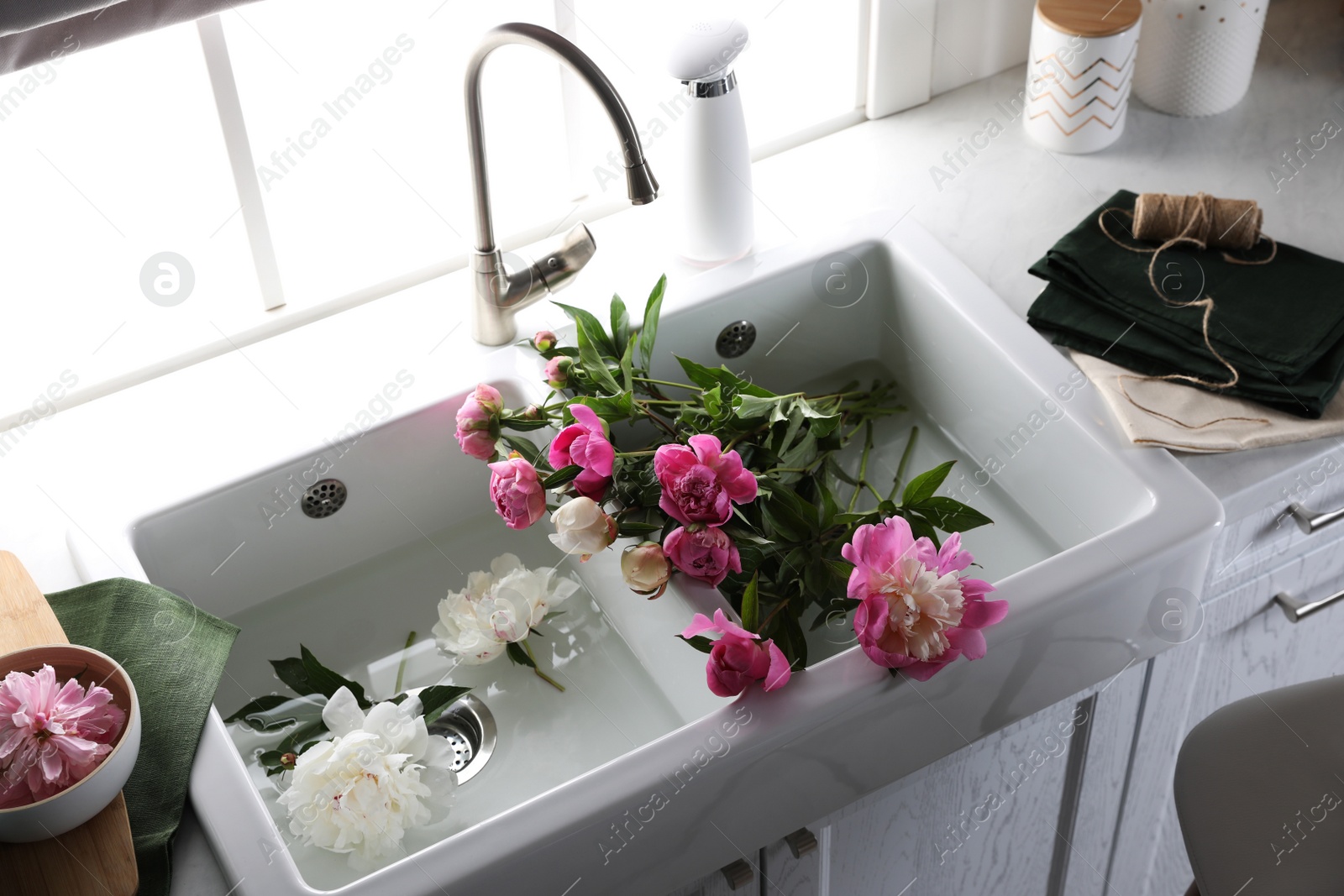 Photo of Bunch of beautiful peonies in kitchen sink