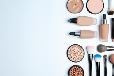 Flat lay composition with skin foundation, powder and beauty accessories on white background. Space for text