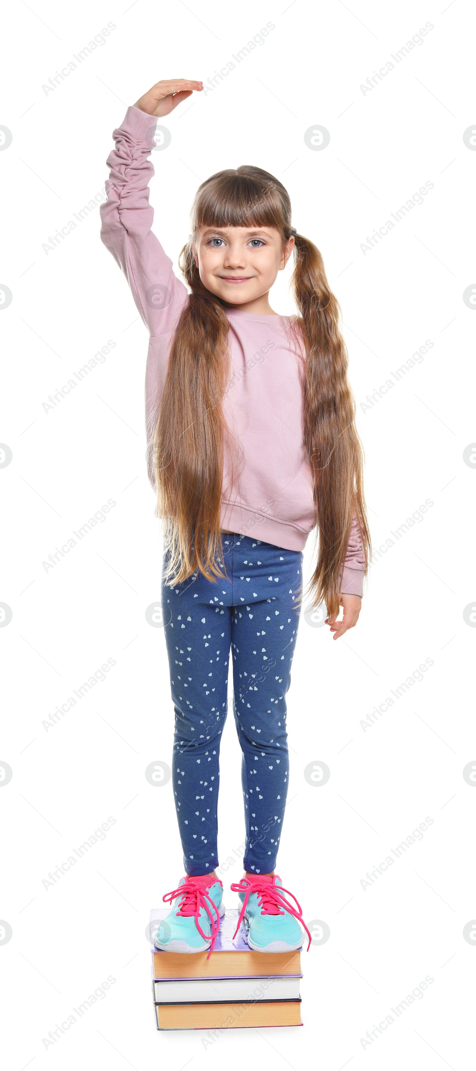 Photo of Little girl measuring her height on white background