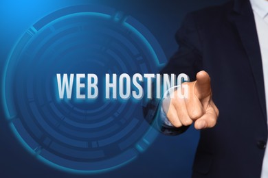 Image of Businessman pointing at phrase WEB HOSTING on virtual screen against blue background, closeup 