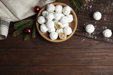 Photo of Flat lay composition with Christmas snowball cookies on wooden table, space for text