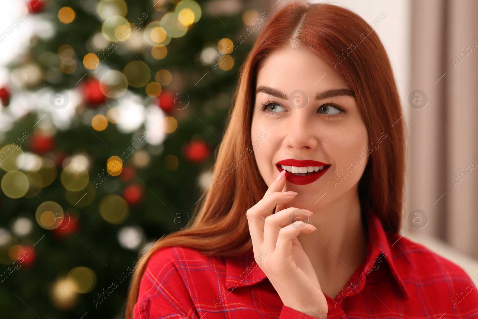Photo of Beautiful young smiling woman against blurred lights, space for text. Celebrating Christmas