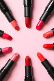 Photo of Frame of bright lipsticks on pink background, flat lay. Space for text