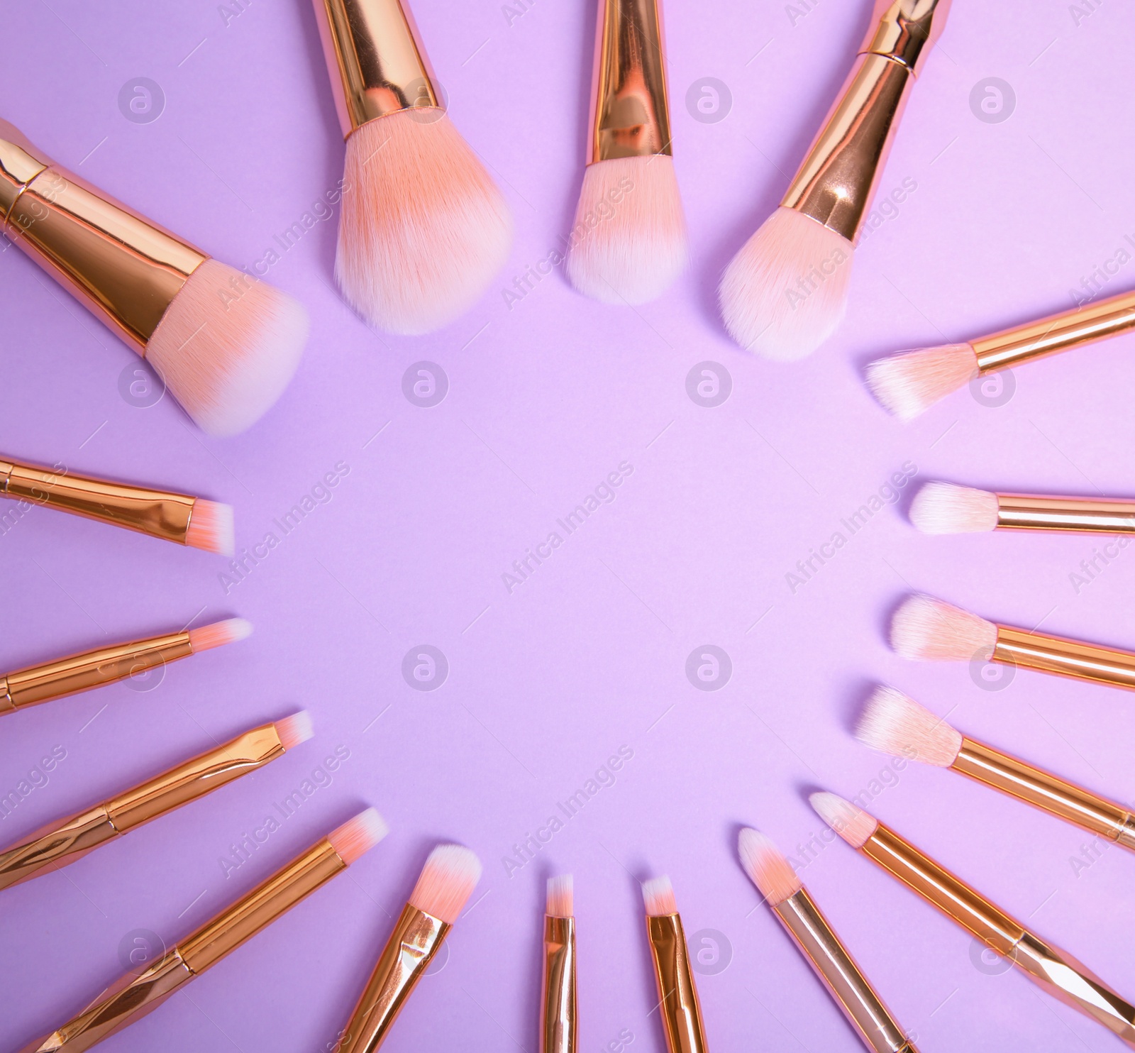 Photo of Flat lay composition with set of professional makeup brushes on lilac background. Space for text