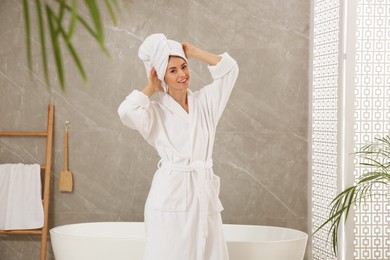 Photo of Beautiful woman wearing white robe in bathroom