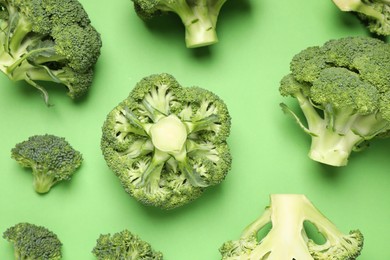 Fresh broccoli on green background, flat lay