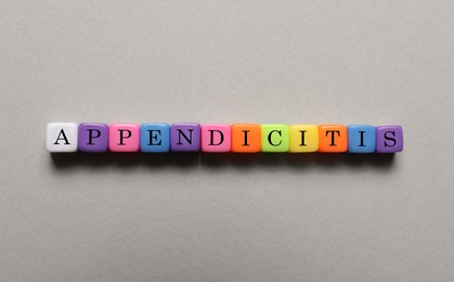 Photo of Word Appendicitis made of color cubes with letters on light background, top view