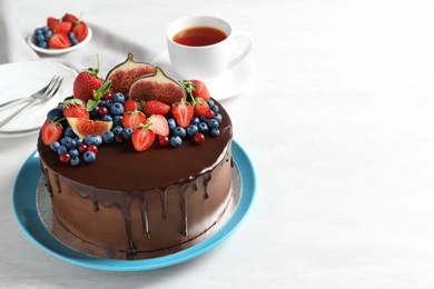 Photo of Fresh delicious homemade chocolate cake with berries on light table. Space for text