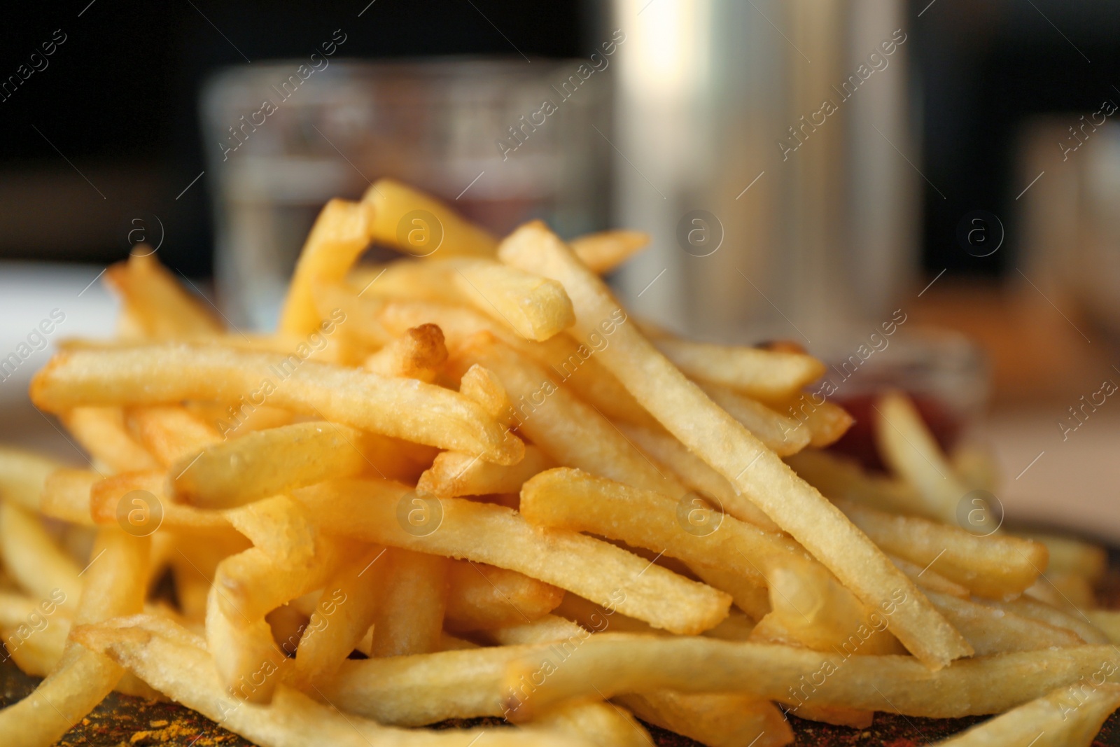 Photo of Tasty French fries served on table in cafe, closeup