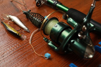 Photo of Fishing tackle. Reel, rod and lures on wooden table, closeup