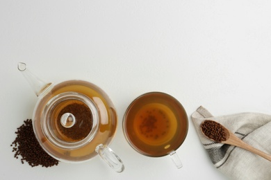 Buckwheat tea and granules on white background, flat lay. Space for text